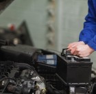 Male mechanic changing car battery