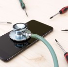89220878 - phone repair and service concept. smartphone being diagnosed with a stethoscope, screwdrivers around