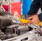 20408400 - closeup of a mechanic checking a car battery at an auto shop